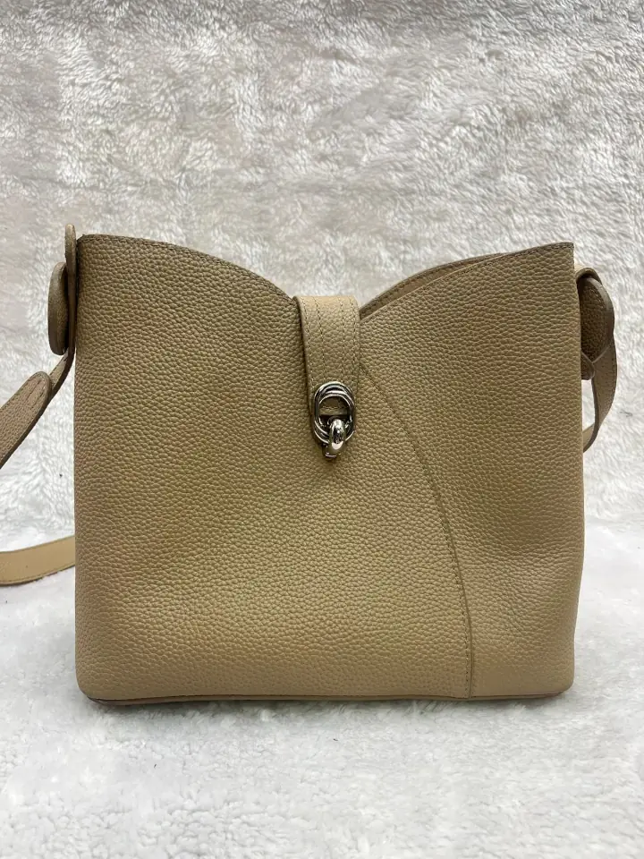 Replaced twist closure of the beige leather hand bag.