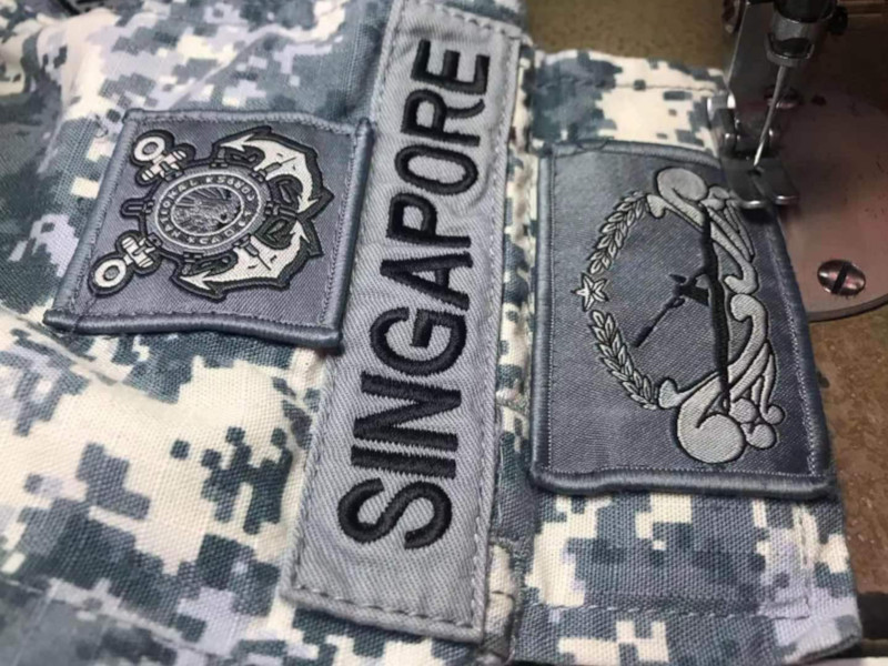 Sewing of Singapore Navy number 4 uniform patches.