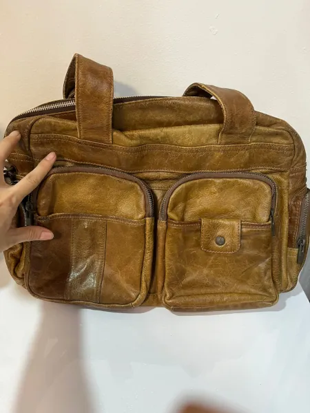 Full view of the repaired brown leather bag.