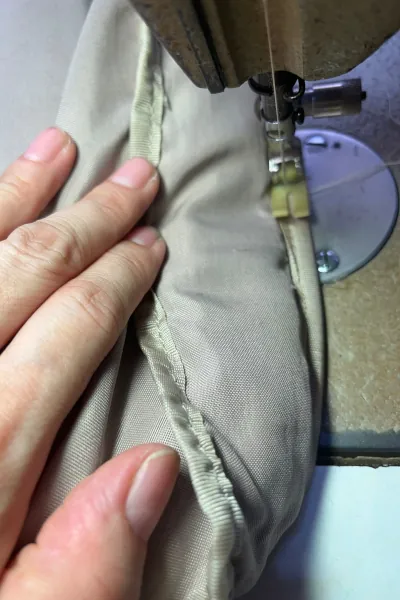 Sewing of the inner lining of the Tumi backpack.