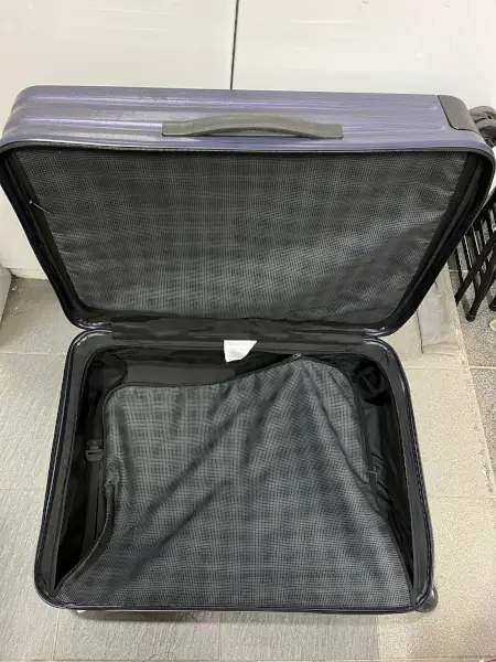 Over head view of a black color luggage showing the split zipper of the internal zipper compartment.