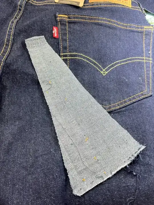 A denim fabric was cut and ready to be sewn onto the hem of the Levi Jeans.