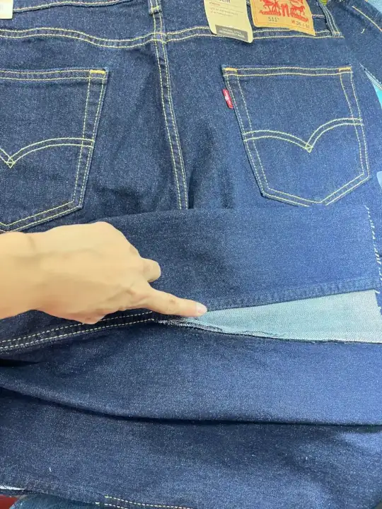 Preparing to sew the denim fabric onto the hem of the Levi Jeans.