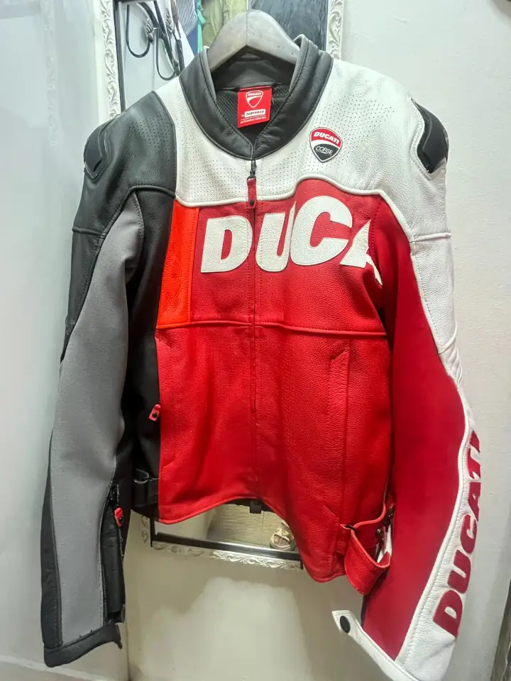 Red, black, and white Ducati motorcycle jacket on a hanger after professional alteration for a better fit.